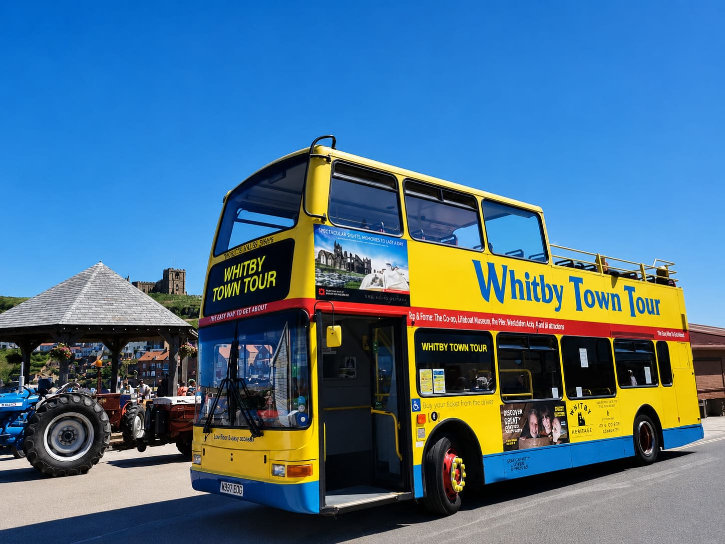 Yellow open-top tour bus running the Whitby Town Tour route, fitted with EasyGuide GPS audio commentary covering the abbey, harbour and town landmarks